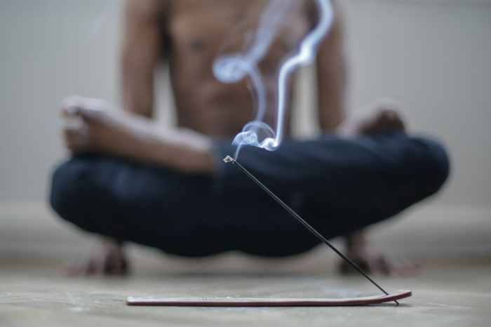 man using incense while doing yoga